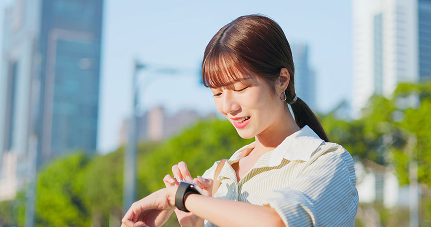 Woman checking her smartwatch on the street in the city.