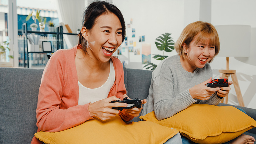 Two Asian women playing a console game.