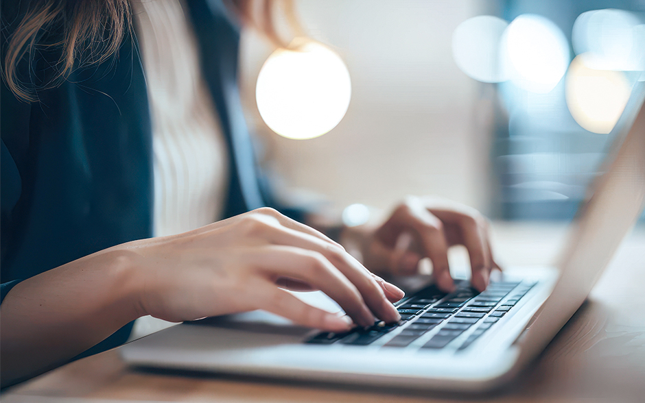 Hands typing on a laptop, reflecting focus and efficiency