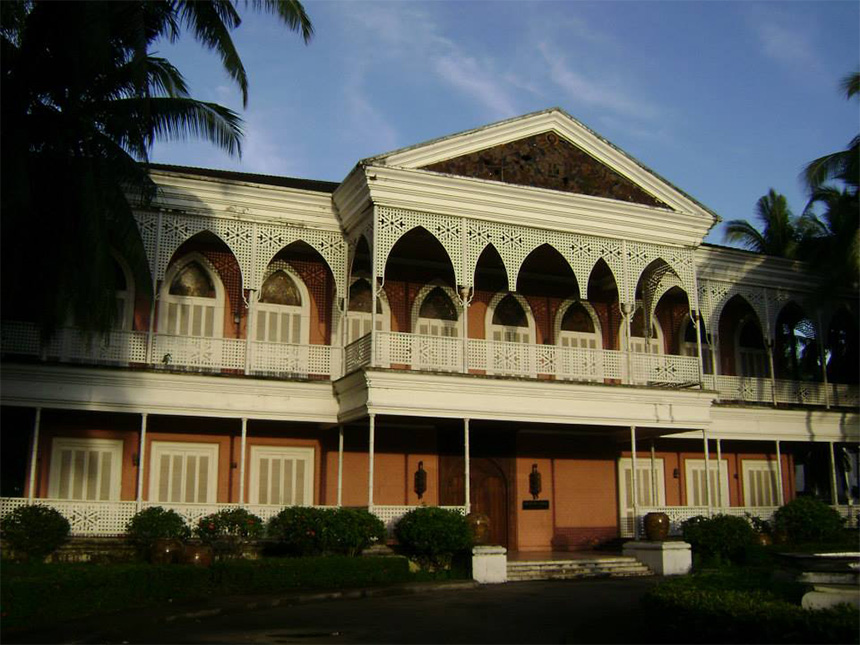 Colonial-style two-story building with arched windows and white latticework.