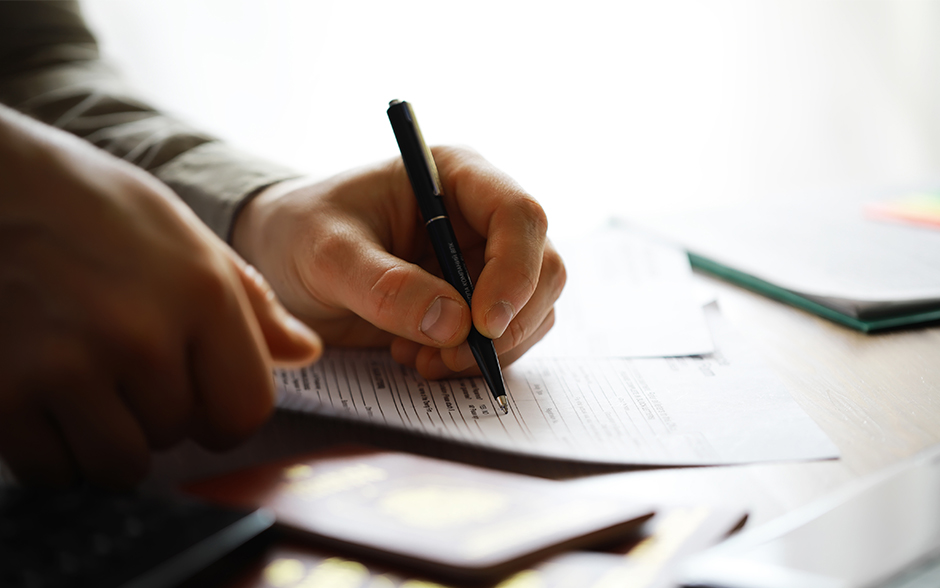 Hands filling out important paperwork.