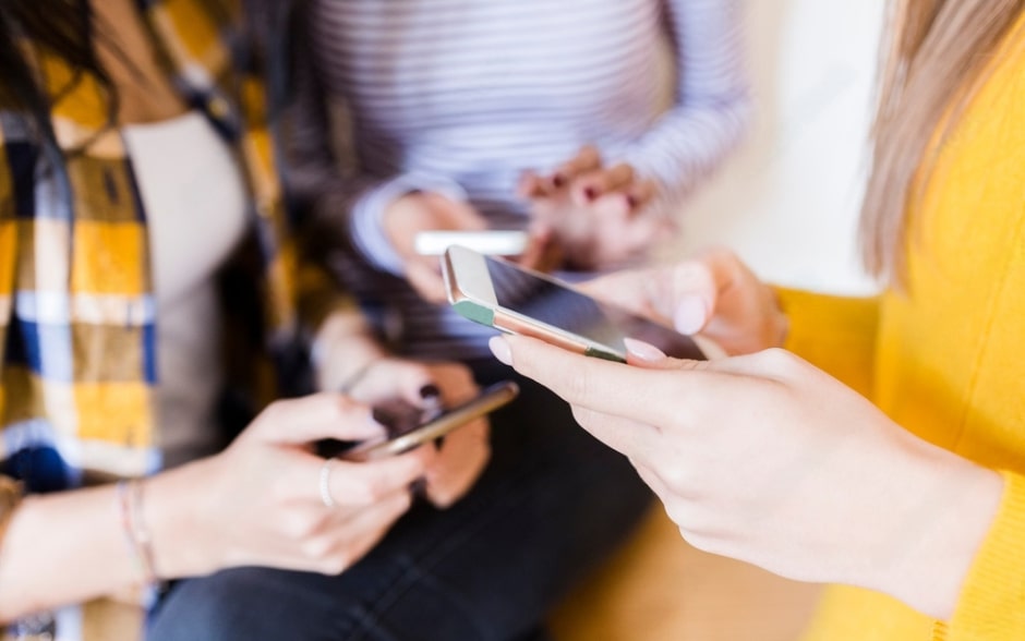Three people holding and using smartphones.