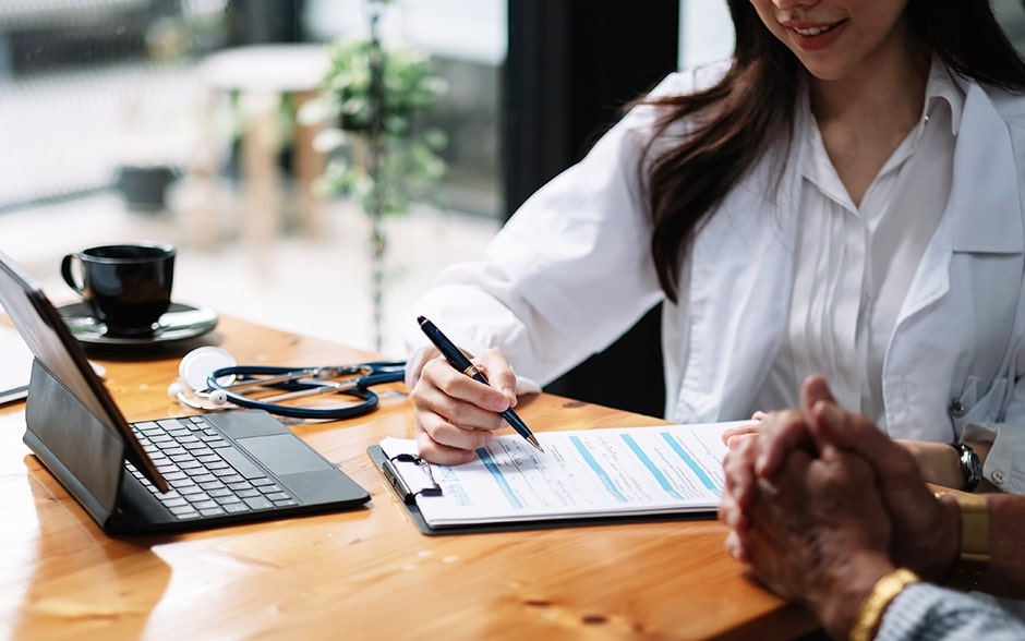 A doctor fills out a medical form while consulting with a patient