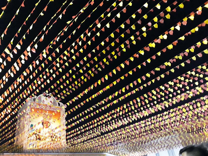 A poster of the Sto. Nino alongside bandaritas above a Sinulog parade.